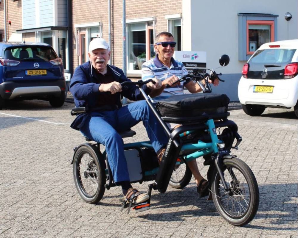 Bewoner stapt op de fiets met vrijwilliger voor een ommetje.